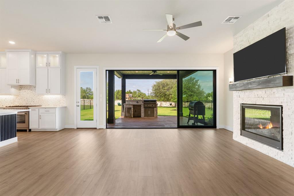 504 Tomichi Trail Austin, TX 78738 - Photo 19 of 36 a view of an empty room with a fireplace and a flat screen tv
