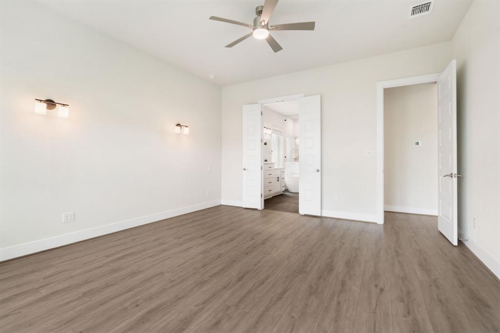 504 Tomichi Trail Austin, TX 78738 - Photo 23 of 36 an empty room with wooden floor and windows