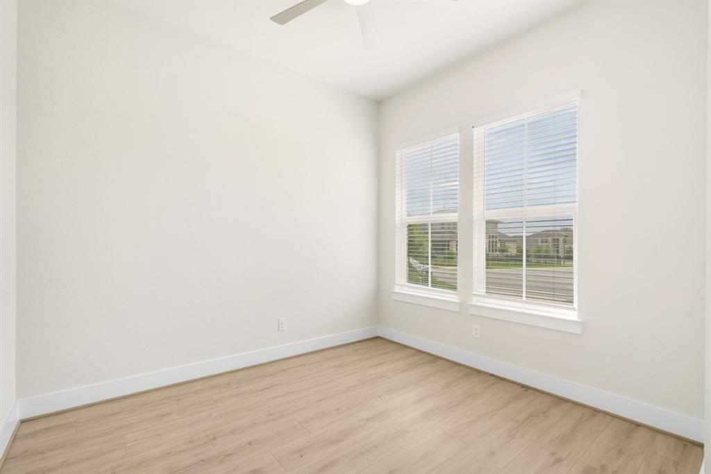 504 Tomichi Trail Austin, TX 78738 - Photo 8 of 36 an empty room with wooden floor and windows