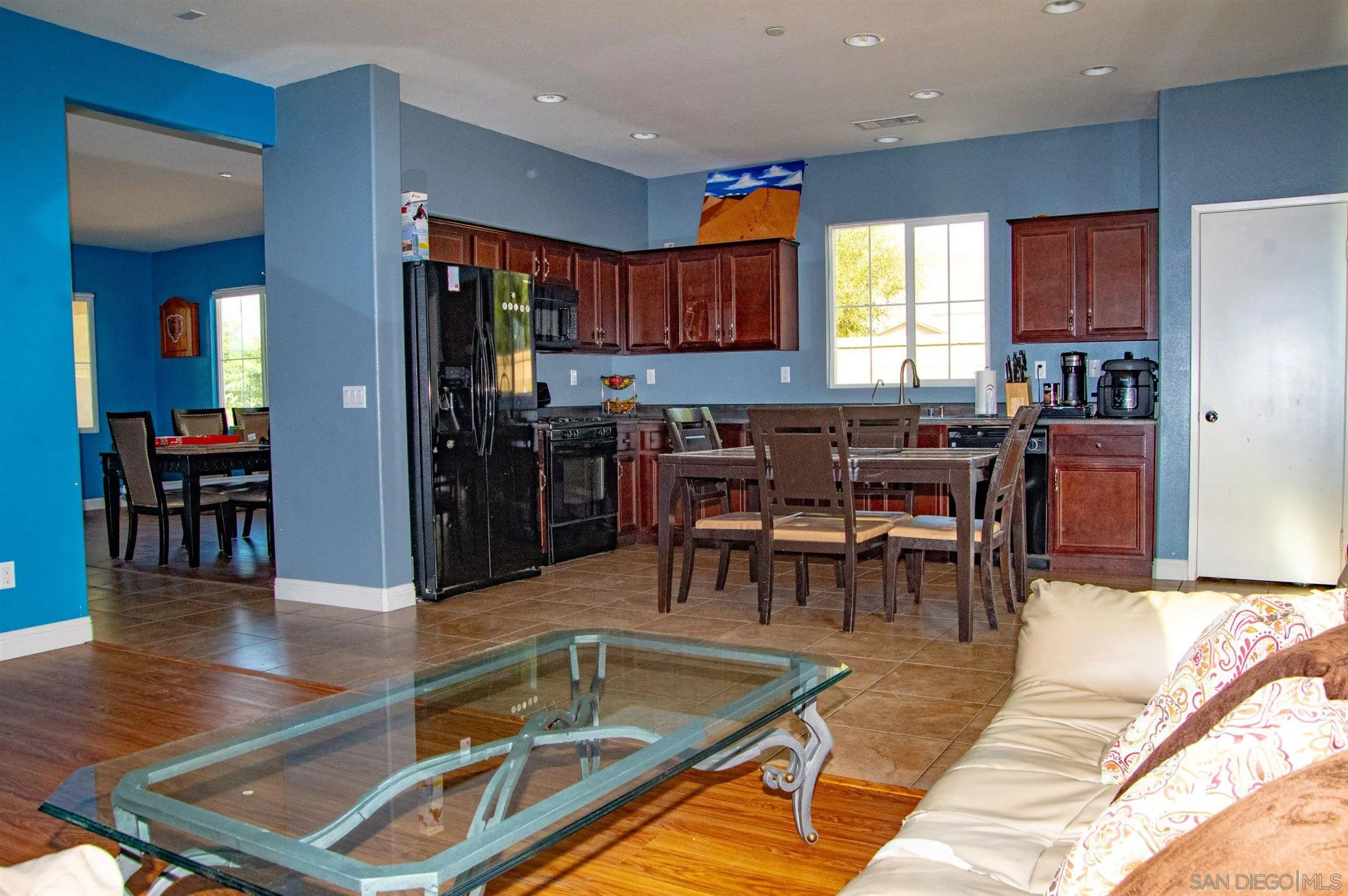2131 Canvas Way San Jacinto, CA 92582 - Photo 11 of 36 a dining hall with stainless steel appliances kitchen island granite countertop a table chairs and a view of living room