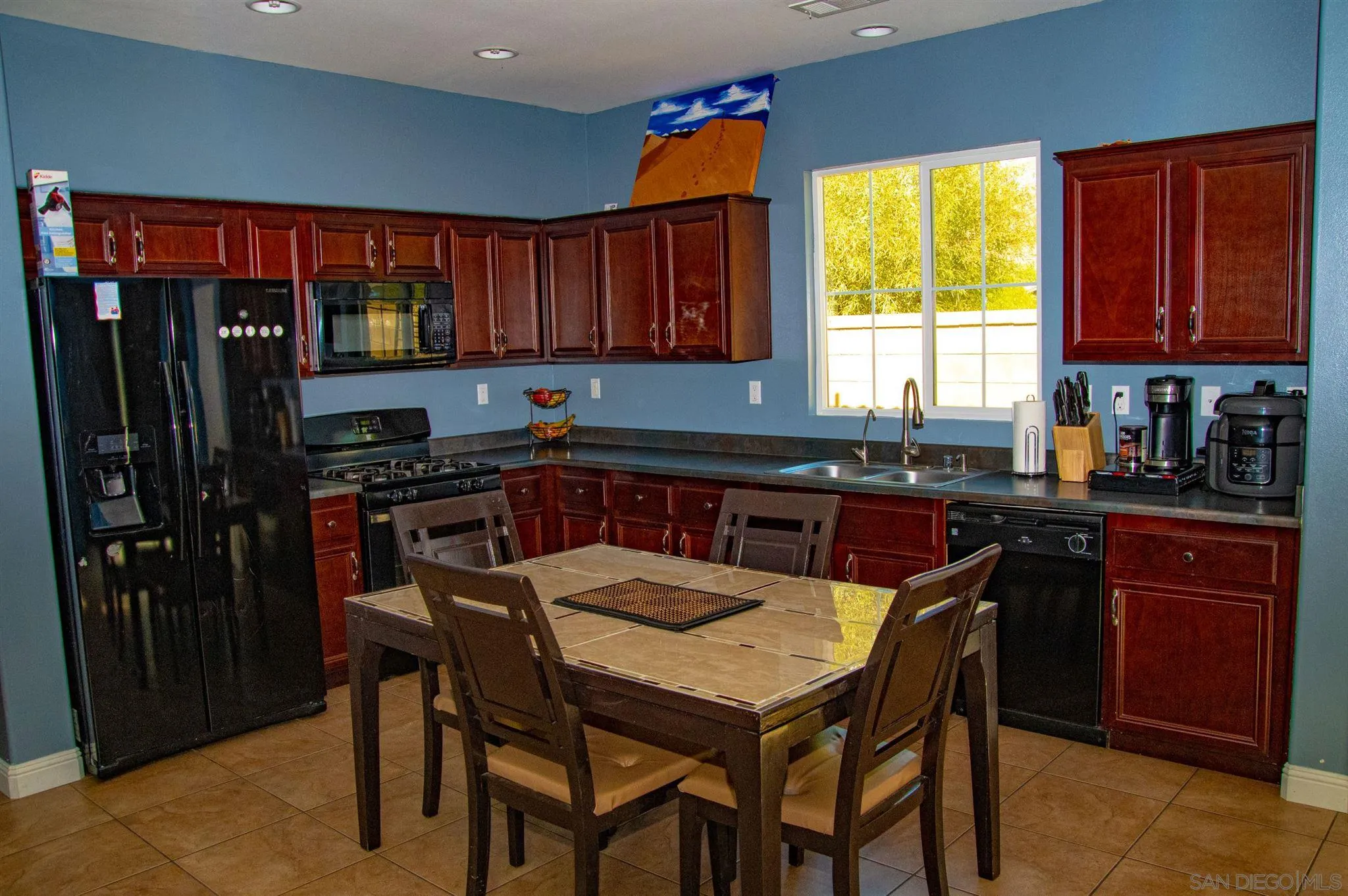 2131 Canvas Way San Jacinto, CA 92582 - Photo 12 of 36 a kitchen with stainless steel appliances granite countertop a sink a stove a refrigerator cabinets and a dining table