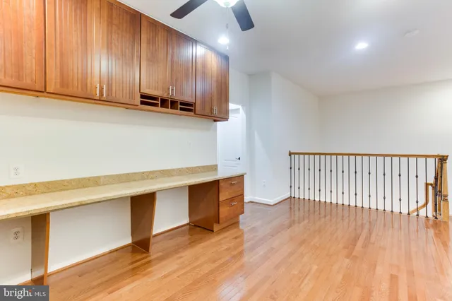 a view of a kitchen with wooden floor and cabinets
