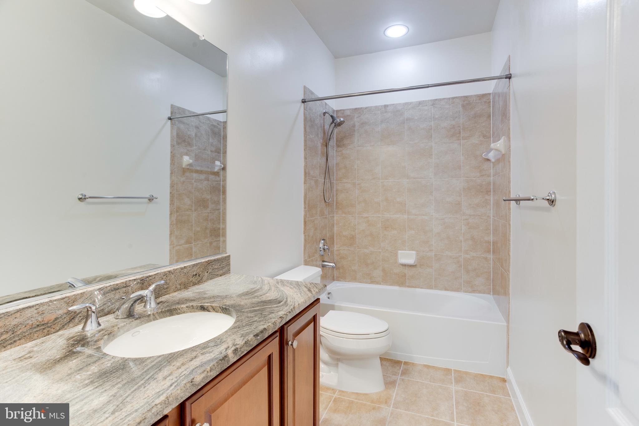18353 Fairway Oaks Square Leesburg, VA 20176 - Photo 47 of 50 a bathroom with a granite countertop sink toilet and shower