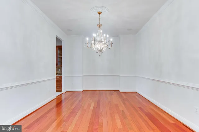 a view of a room with wooden floor and chandelier