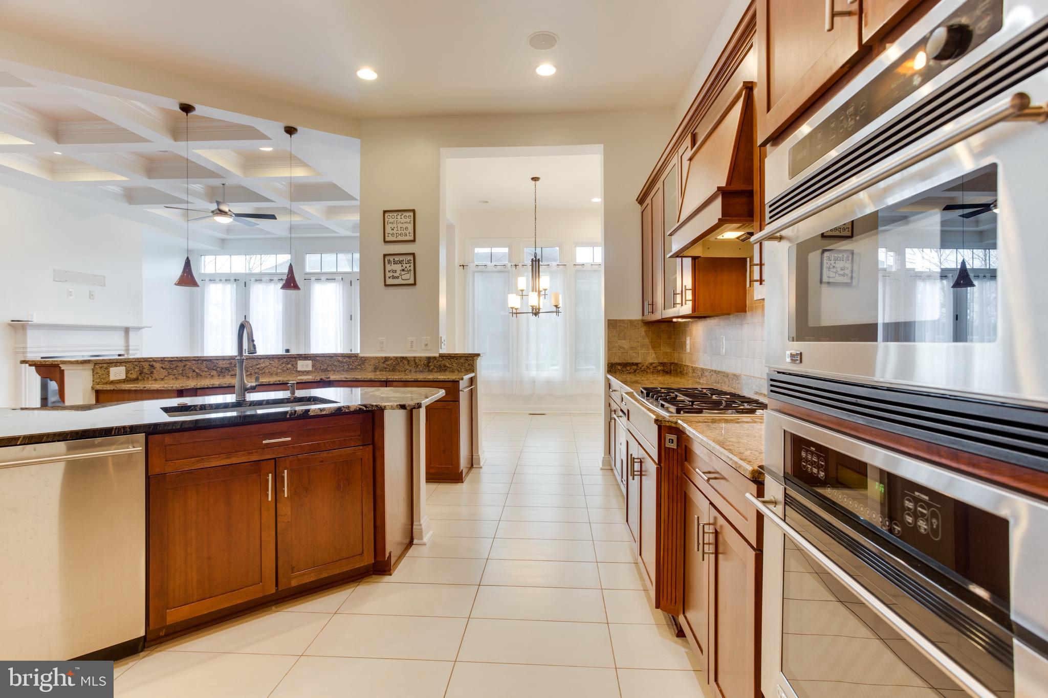 18353 Fairway Oaks Square Leesburg, VA 20176 - Photo 9 of 50 a kitchen with stainless steel appliances granite countertop a stove a sink and a refrigerator