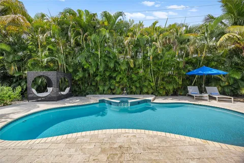a view of a swimming pool with lawn chairs under an umbrella
