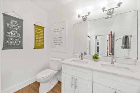 a bathroom with a granite countertop sink and a toilet