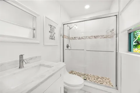 a bathroom with a sink a toilet and shower