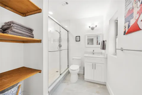 a bathroom with a sink a toilet and shower