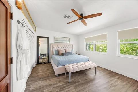 a bedroom with a bed and wooden floor