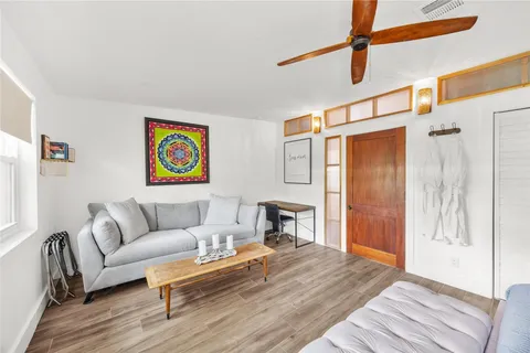 a living room with furniture and a wooden floor