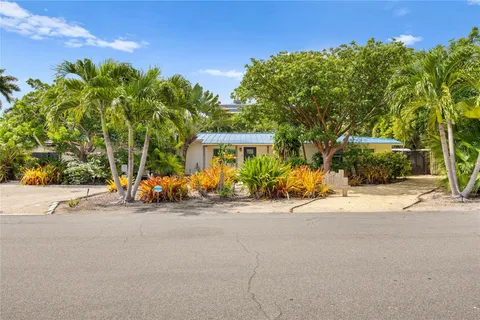 a view of a street with a building and couple of cars parked in front of it