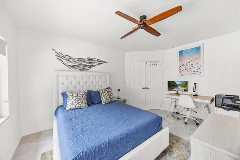 a bedroom with a bed a couch and a chandelier