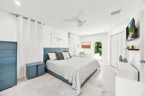 a bedroom with a balcony a bed and a flat screen tv