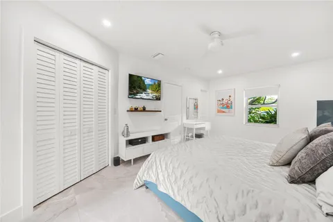 a large bedroom with a bed and a flat screen tv