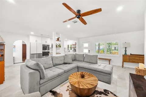 a living room with furniture and a ceiling fan