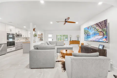 a living room with furniture and a view of kitchen