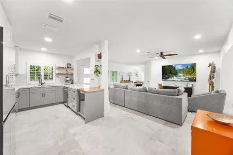 a large white kitchen with cabinets a sink and a stove