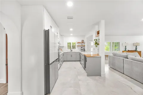 a large white kitchen with cabinets and stainless steel appliances