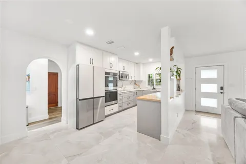a kitchen with a refrigerator and a stove top oven
