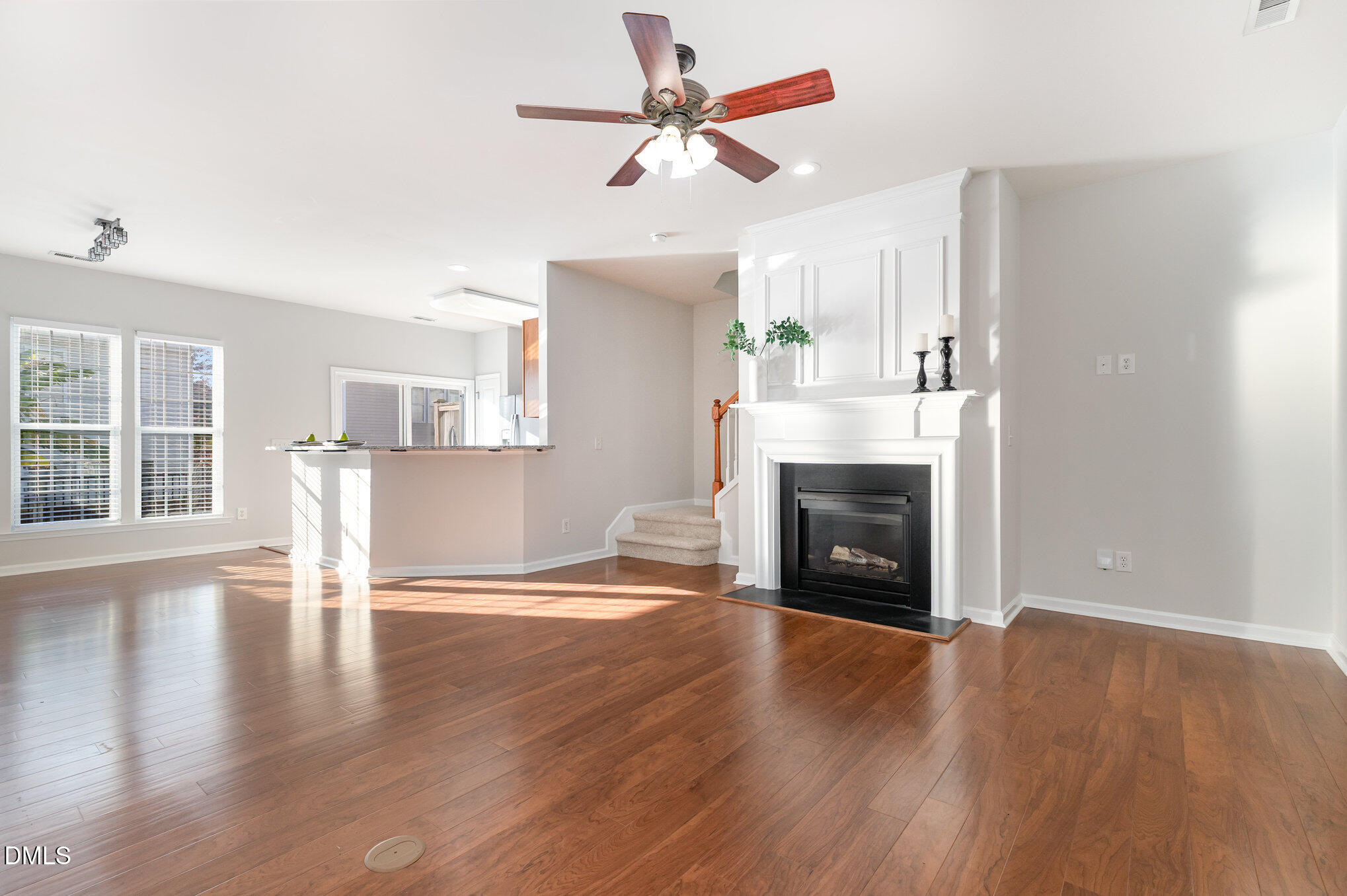 8325 Pilots View Drive Raleigh, NC 27617 - Photo 8 of 28 an empty room with wooden floor fireplace and windows