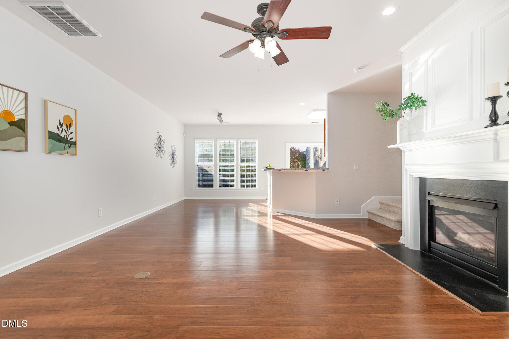 8325 Pilots View Drive Raleigh, NC 27617 - Photo 10 of 28 a view of empty room with wooden floor fireplace and windows