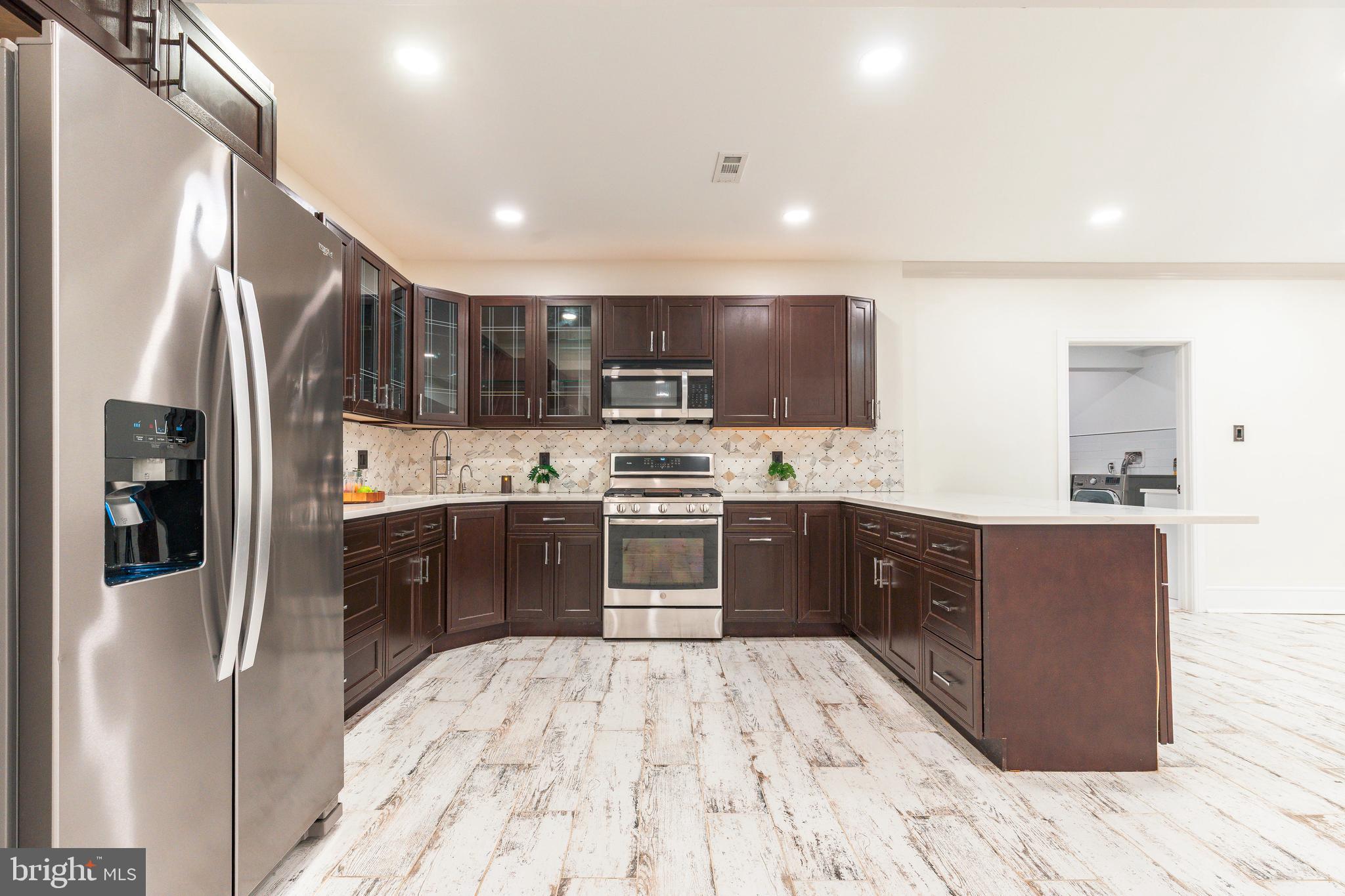 1226 Norwalk Road Philadelphia, PA 19115 - Photo 29 of 68 a kitchen with stainless steel appliances granite countertop a refrigerator and a stove top oven