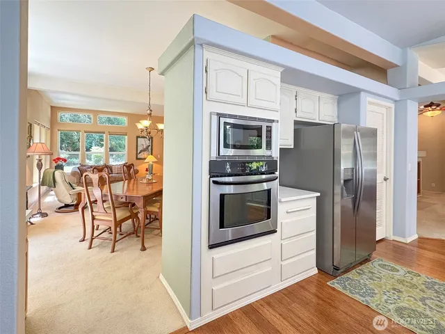 a kitchen with stainless steel appliances granite countertop a refrigerator and a stove top oven