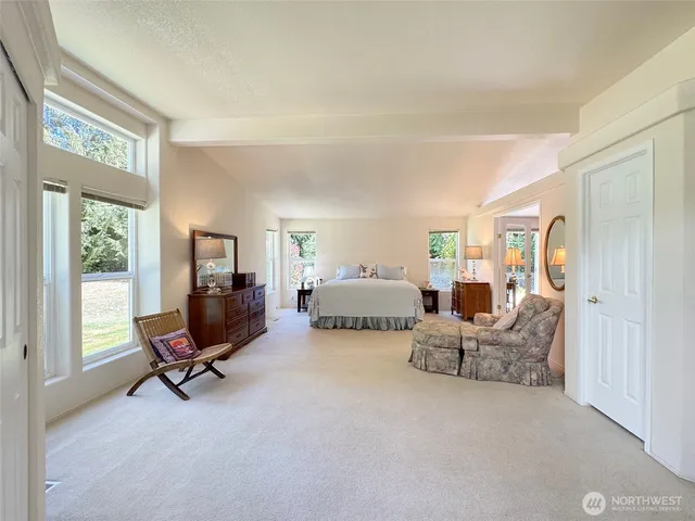 a spacious bedroom with a bed and a large window