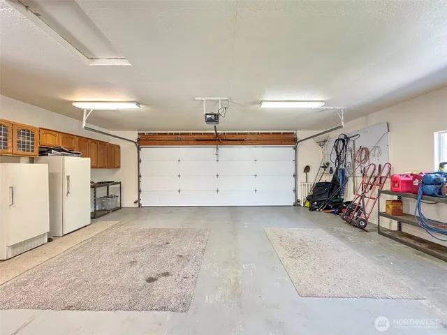 a backyard of a house with table and chairs plants and large trees