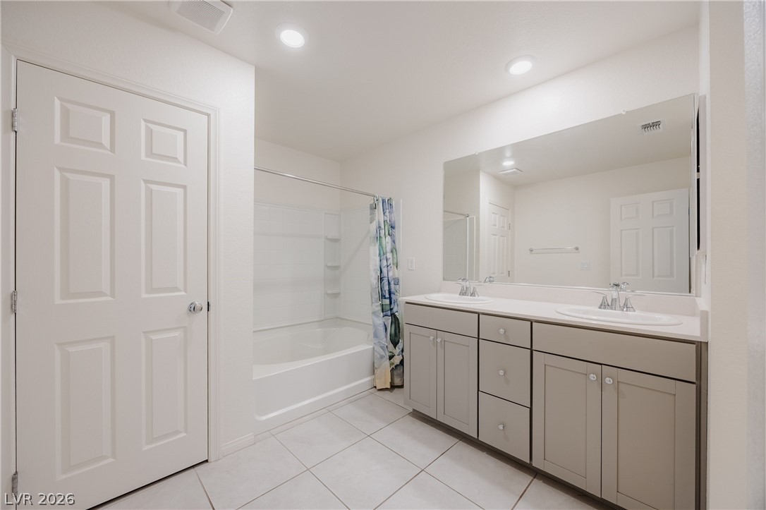 5927 Coja Street Las Vegas, NV 89113 - Photo 17 of 32 Full bathroom with tile patterned flooring, shower / bath combo with shower curtain, double vanity, and recessed lighting