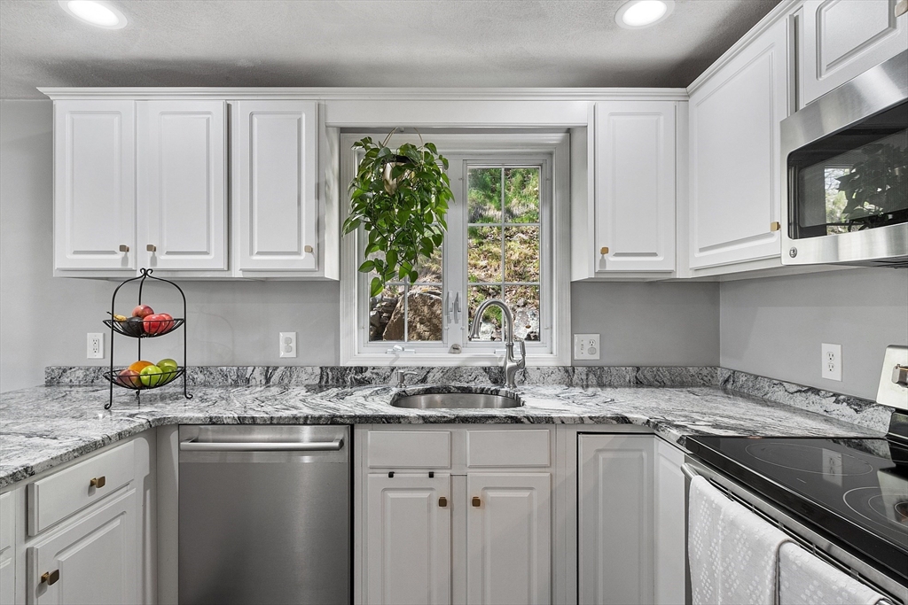 10 Station Road Salem, MA 01970 - Photo 4 of 37 a kitchen with granite countertop white cabinets white appliances and a sink