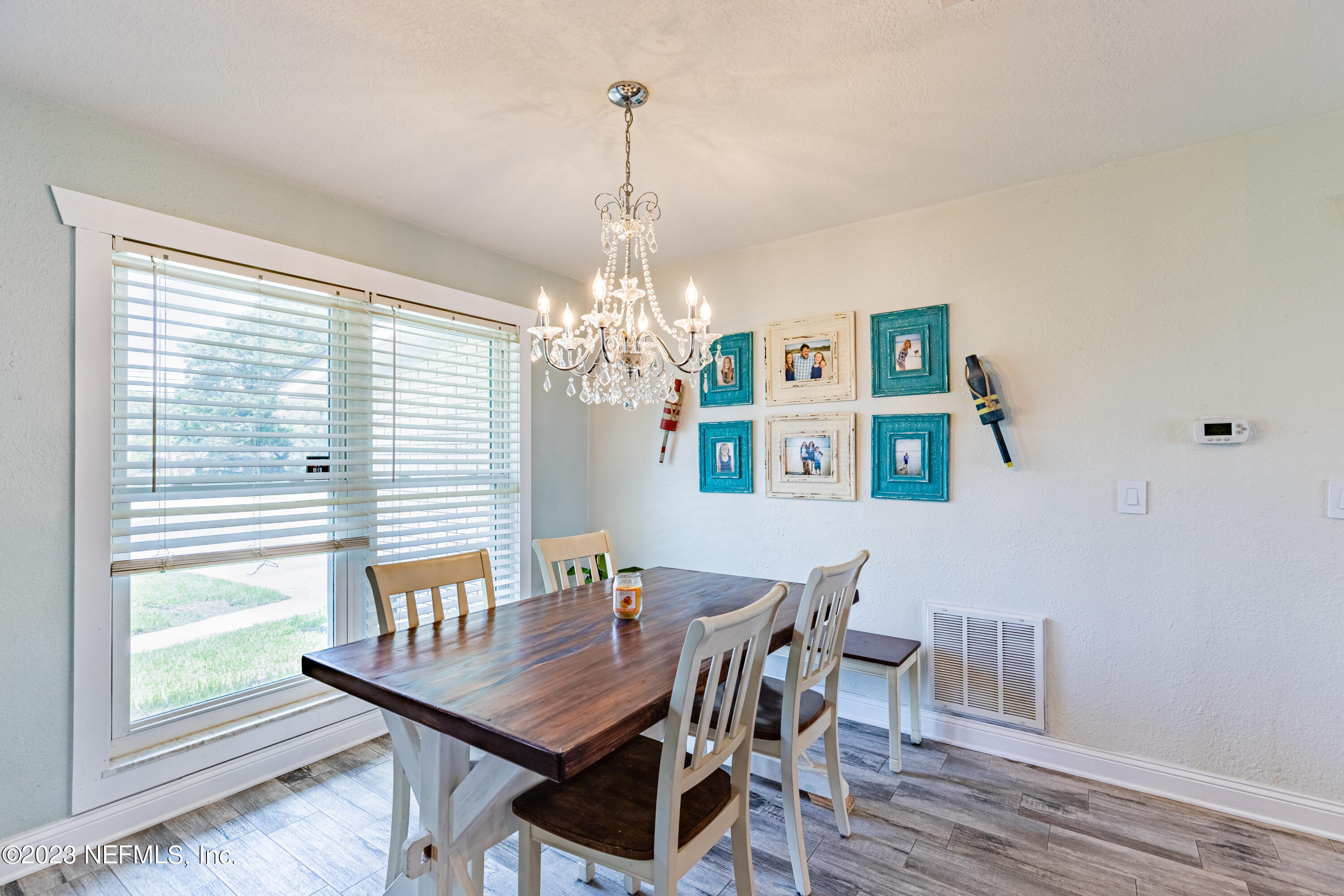6540 Heidi Road Jacksonville, FL 32277 - Photo 7 of 30 a view of a dining room with furniture a chandelier and wooden floor