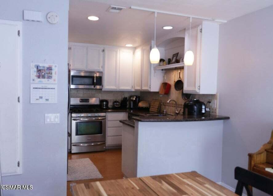 2388 Royal Avenue, Unit 26 Simi Valley, CA 93065 - Photo 5 of 11 a kitchen with kitchen island a sink stainless steel appliances and cabinets