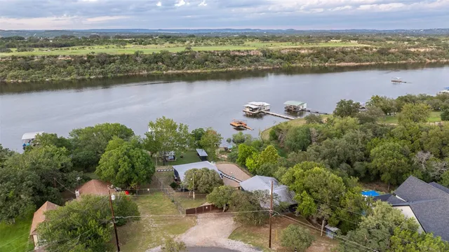 an aerial view of a house with a yard and lake view
