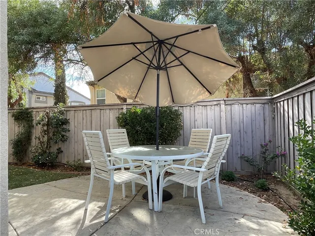 a view of patio with table and chairs under an umbrella