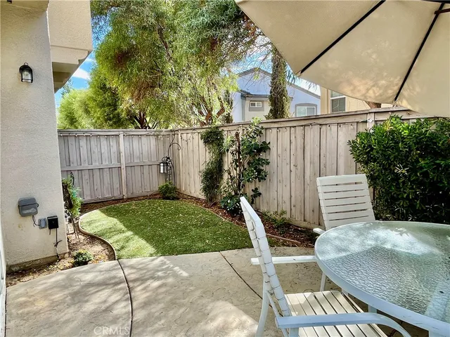 a view of a chair and table in backyard of the house