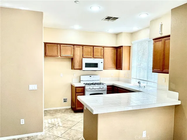 a kitchen with granite countertop a sink a stove and refrigerator
