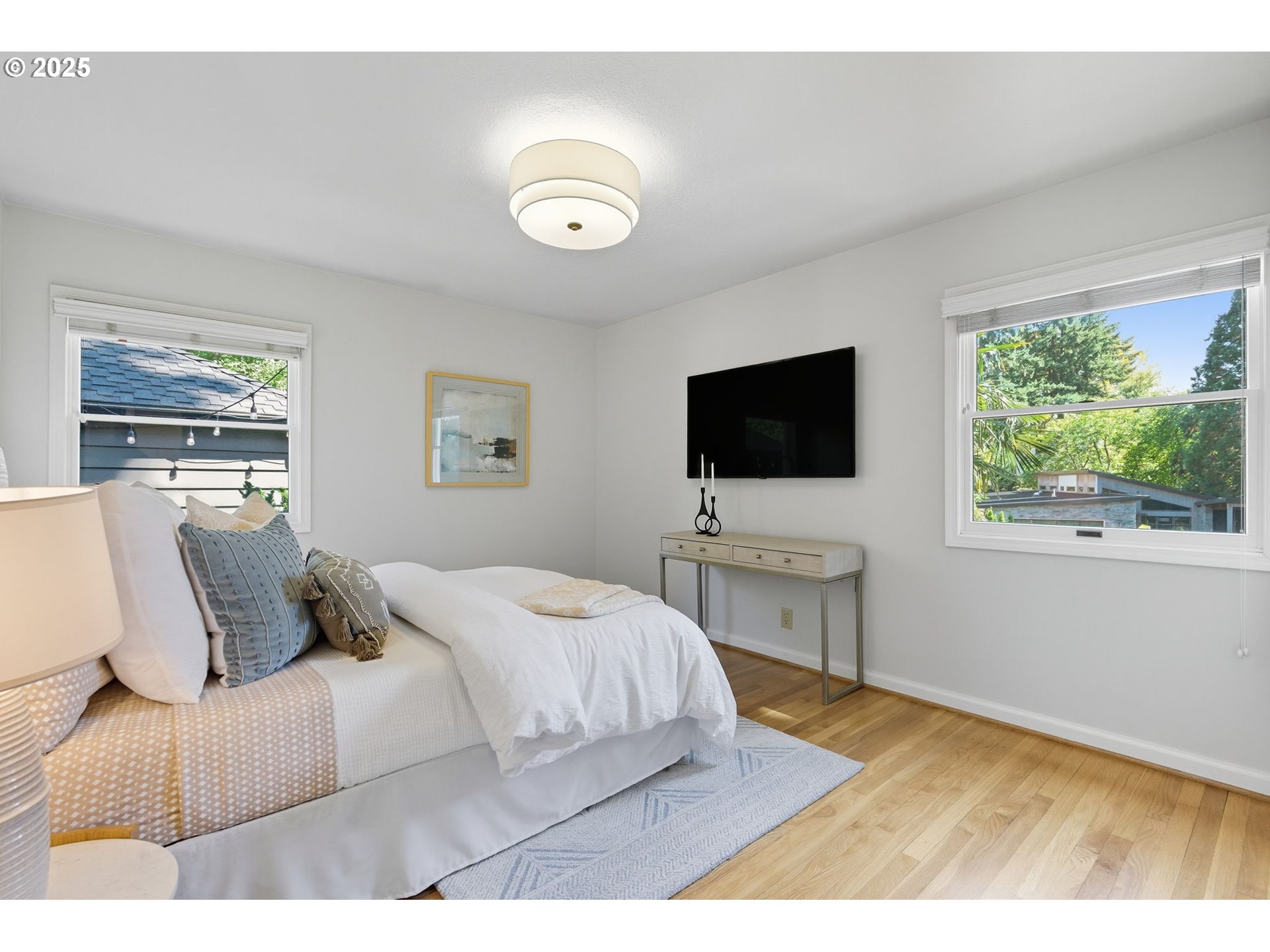 3190 Southwest Ridgewood Avenue Portland, OR 97225 - Photo 19 of 41 a bedroom with a bed tv on table and a window