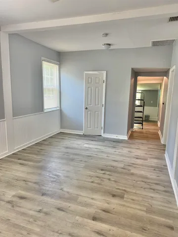a view of empty room with wooden floor