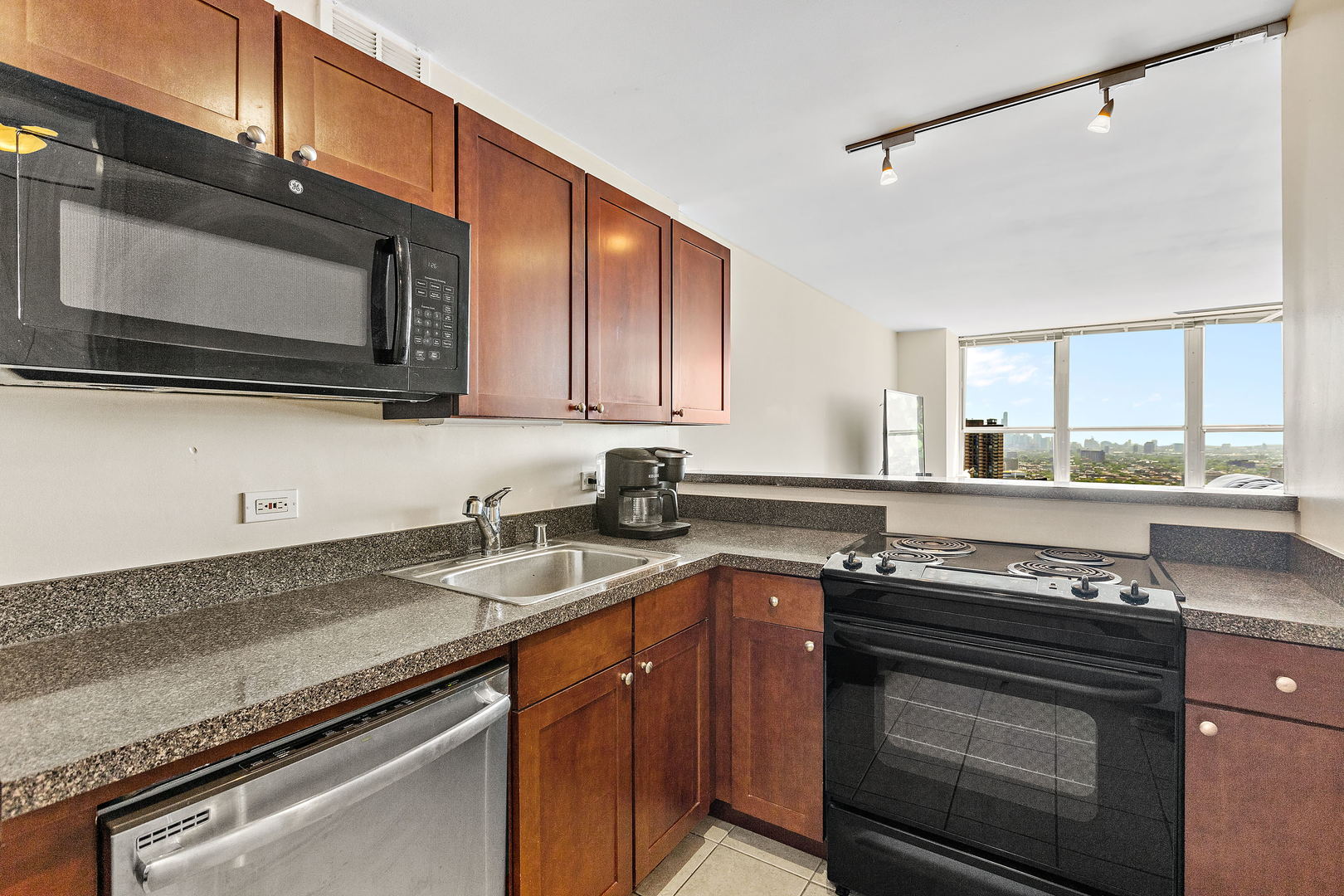 655 West Irving Park Road, Unit 4509 Chicago, IL 60613 - Photo 4 of 22 a kitchen with stainless steel appliances granite countertop a sink stove and microwave