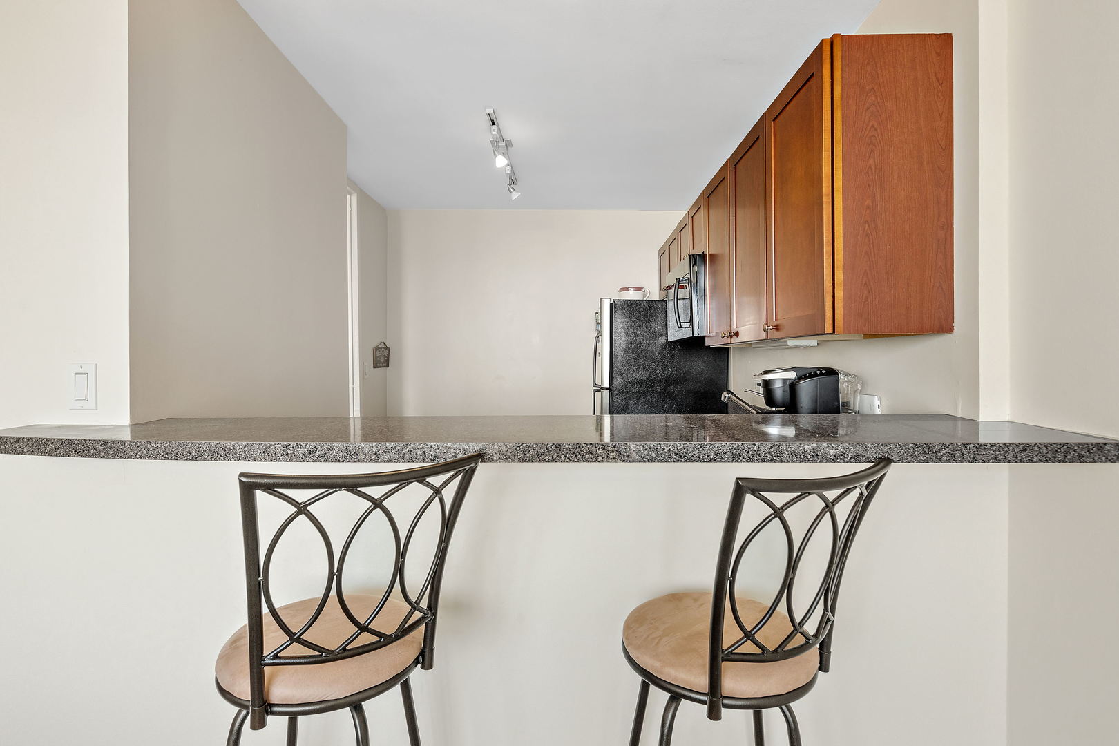 655 West Irving Park Road, Unit 4509 Chicago, IL 60613 - Photo 5 of 22 a kitchen with stainless steel appliances granite countertop a table chairs in it and wooden floors