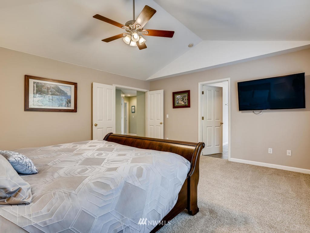 18718 Southeast 144th Street Renton, WA 98059 - Photo 13 of 25 a bedroom with a large bed and a flat screen tv