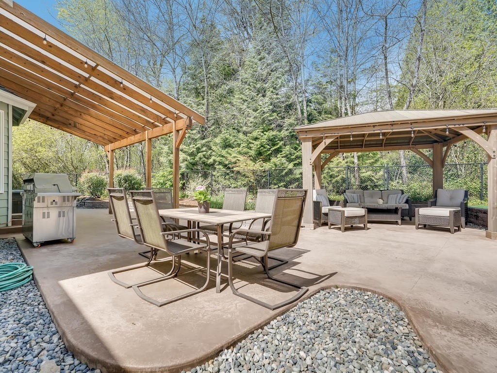 18718 Southeast 144th Street Renton, WA 98059 - Photo 21 of 25 a view of a patio with table and chairs potted plants with wooden floor