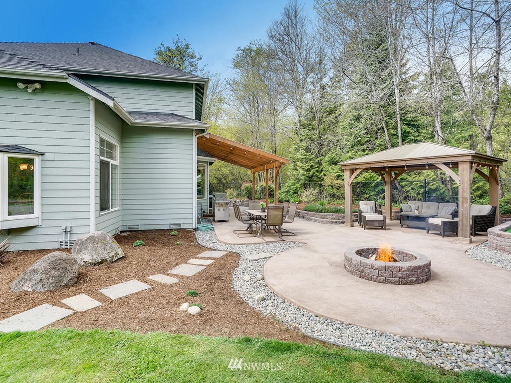 18718 Southeast 144th Street Renton, WA 98059 - Photo 24 of 25 a backyard of a house with table and chairs under an umbrella