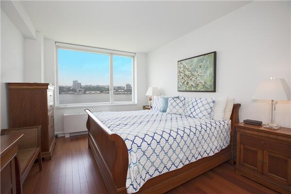 100 Riverside Boulevard, Unit 23D Manhattan, NY 10069 - Photo 5 of 13 a bedroom with a bed window and wooden floor