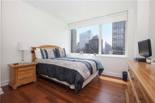 100 Riverside Boulevard, Unit 23D Manhattan, NY 10069 - Photo 6 of 13 a bedroom with a bed and a flat tv screen on a dresser