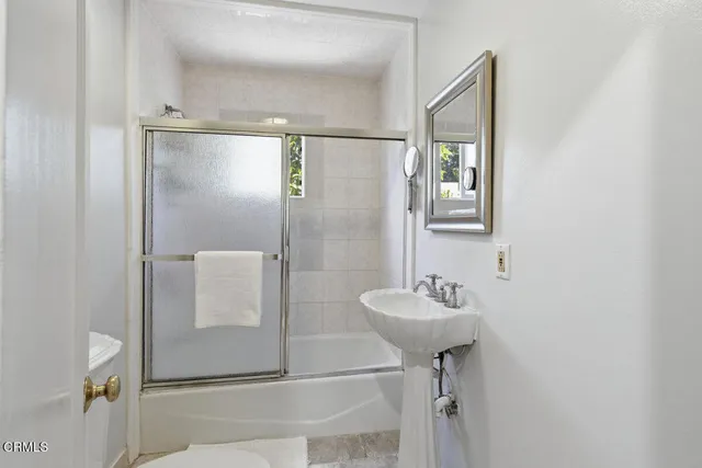 a bathroom with a sink mirror and shower