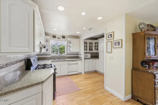 a kitchen with stainless steel appliances granite countertop a sink and cabinets