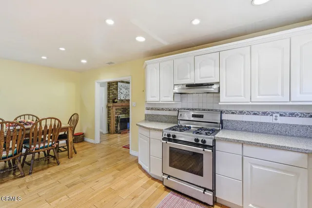 a kitchen with stainless steel appliances granite countertop a stove a sink and a microwave